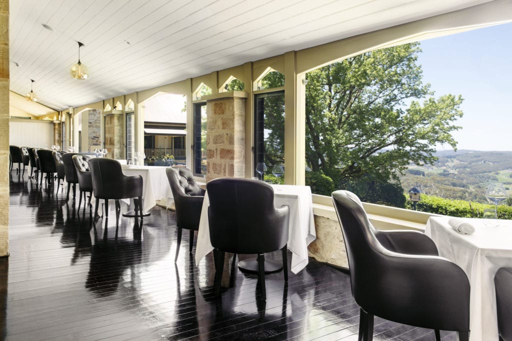 Dining room at the Mount Lofty House with leather chair, and crisp white linen table cloths