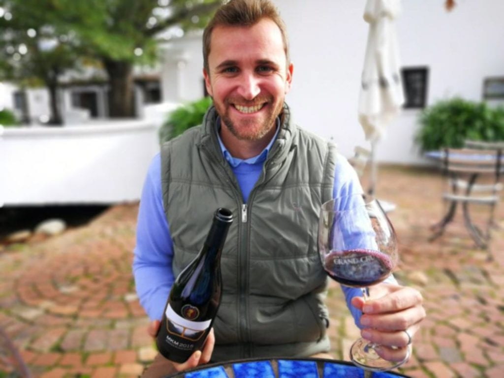 Clayton Reabow holding a glass of wine 