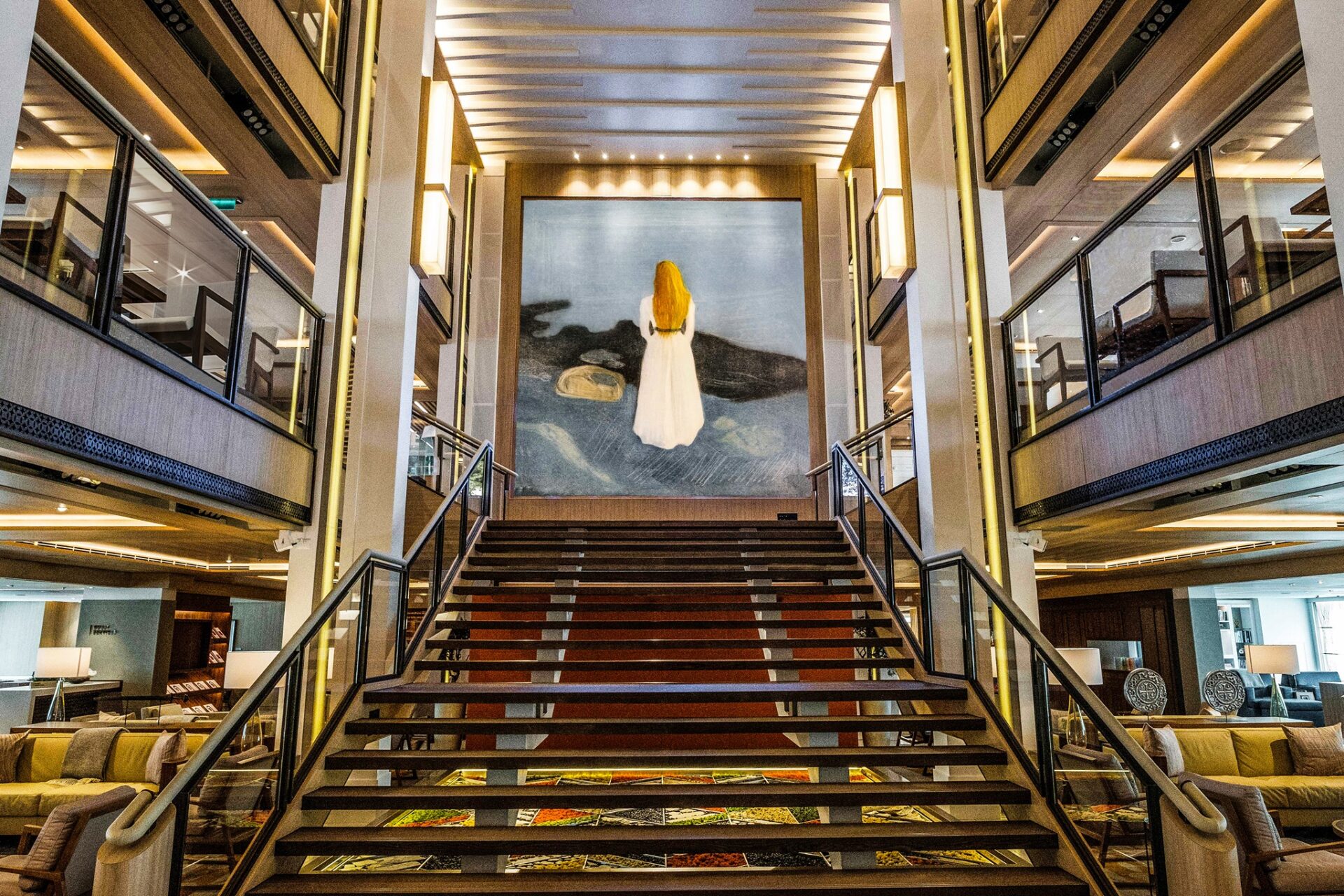UK cruises are the perfect luxury holiday option. Here, a tasteful piece of artwork showing a woman walking away sits at the top of a grand staircase.