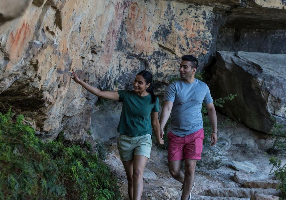 A couple hiking in the Blue Mountains, holding hands and smiling.