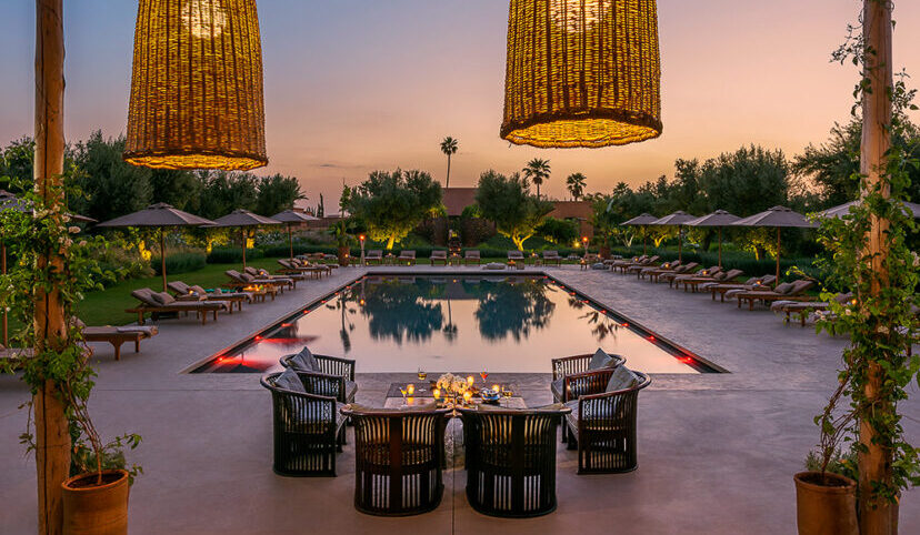 A large pool reflects the soft Maghreb sunset.